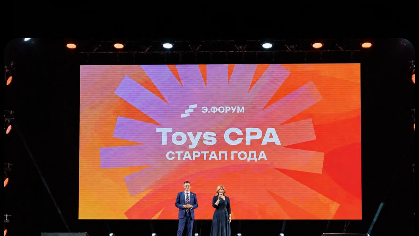 Сцена форума с надписью TOYS CPA — стартап года